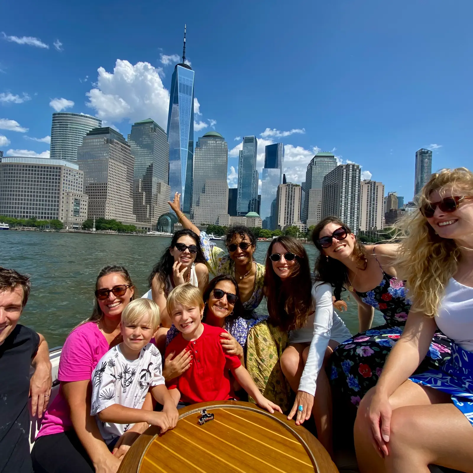 A celebration group in colorful leis cruising past the Statue of Liberty