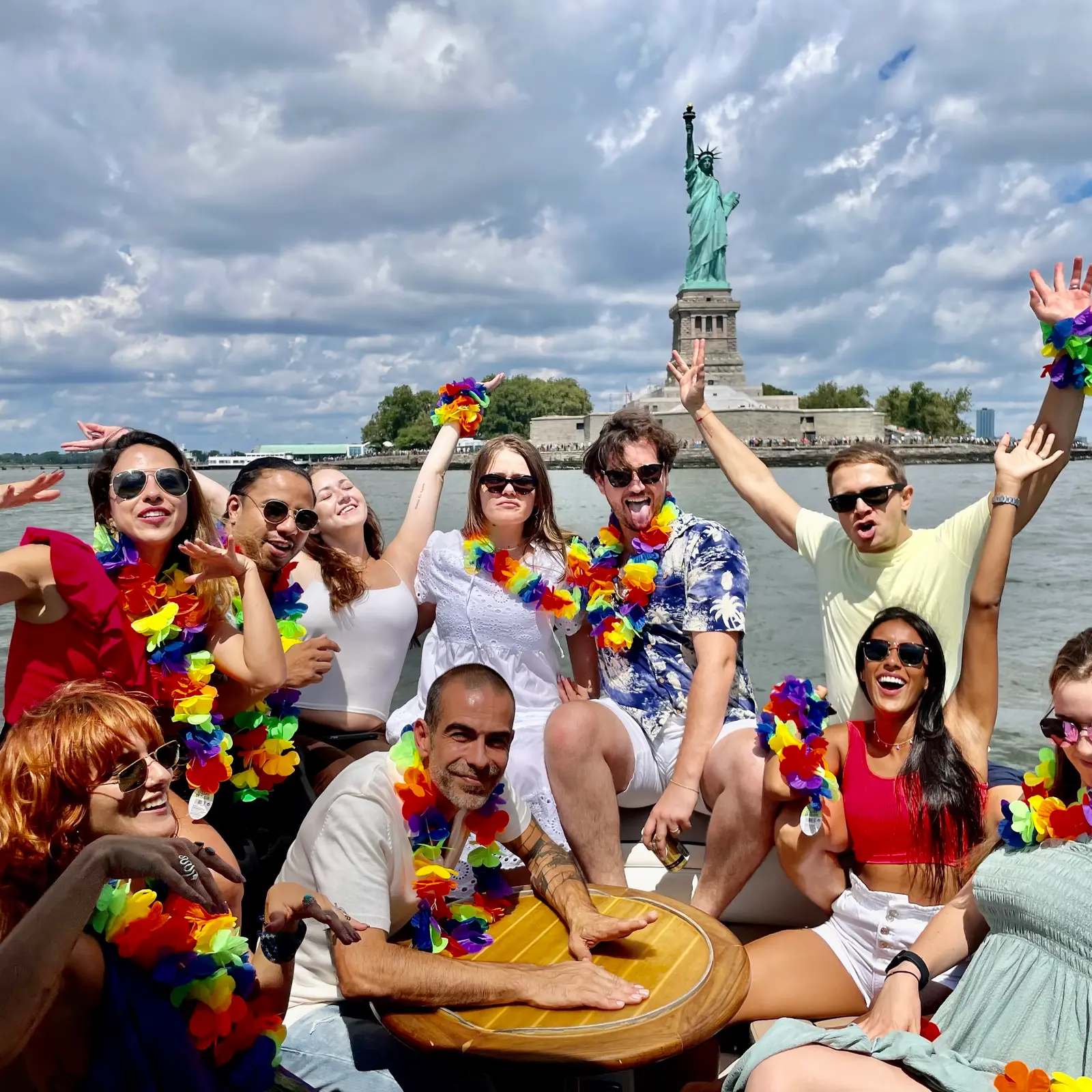 A celebration group in colorful leis cruising past the Statue of Liberty