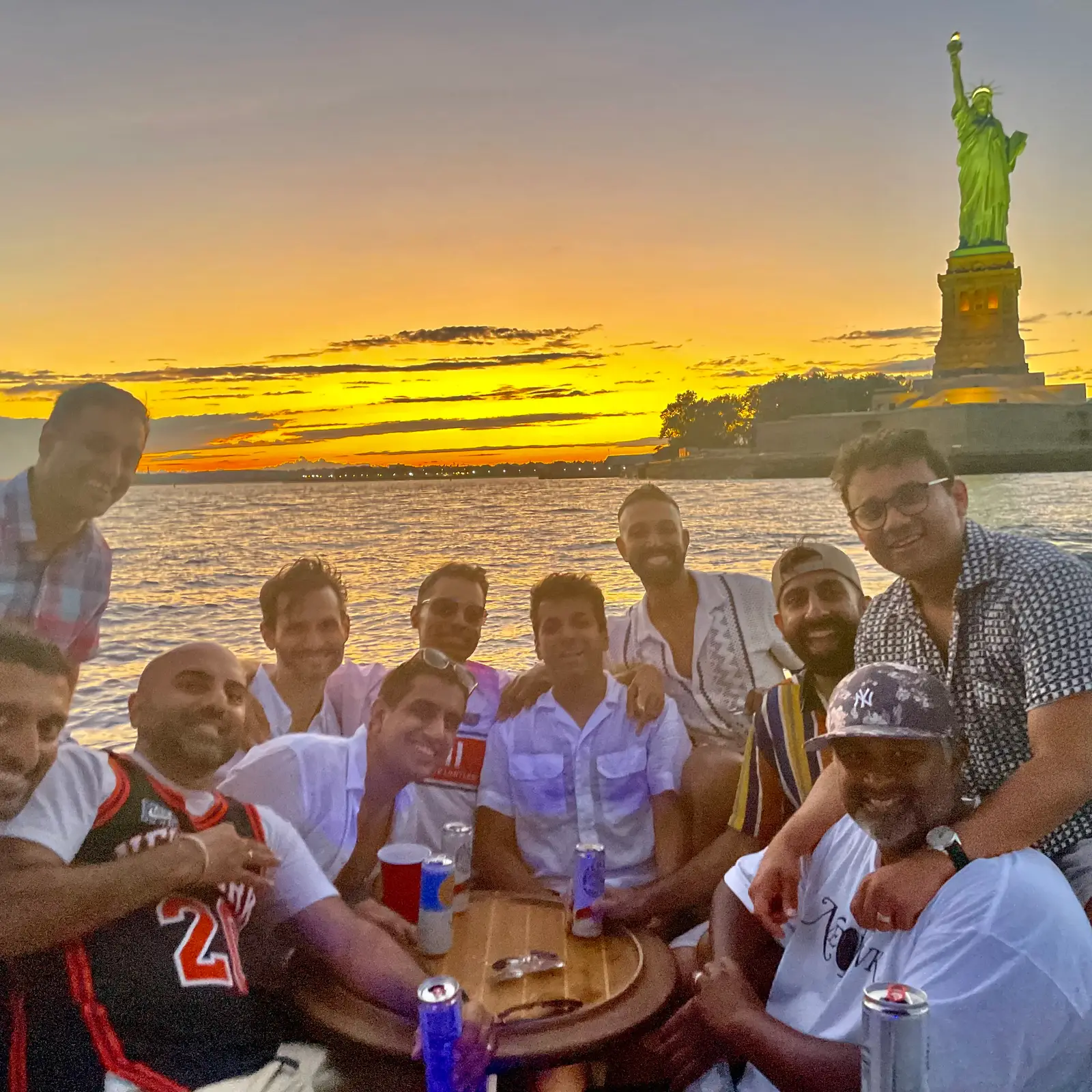 A group of friends celebrating a sunset cruise near the Statue of Liberty